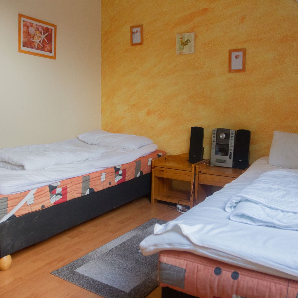 Schlafzimmer mit Stereoanlage und zwei Einzelbetten