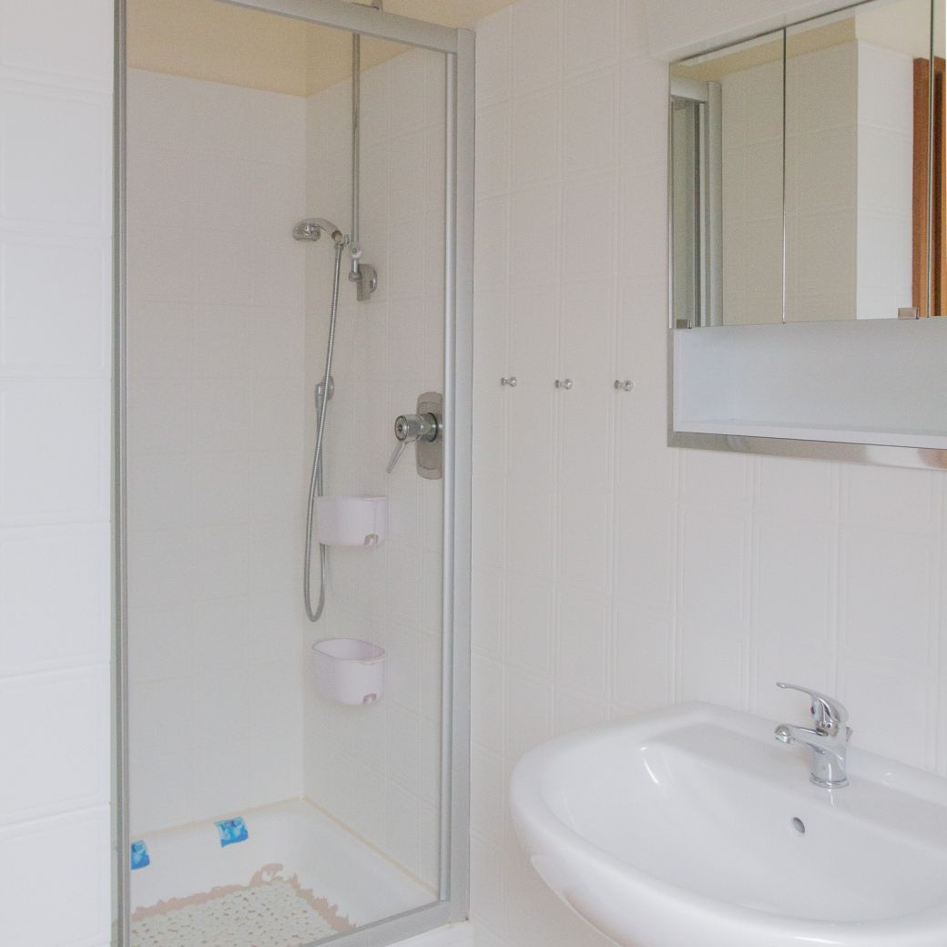 Badezimmer mit Dusche, Waschbecken & Spiegelschrank