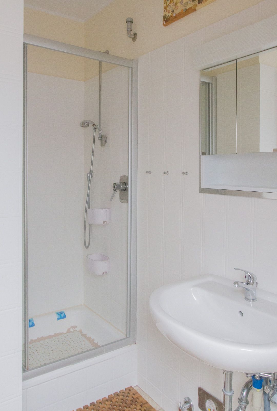 Badezimmer mit Dusche, Waschbecken & Spiegelschrank